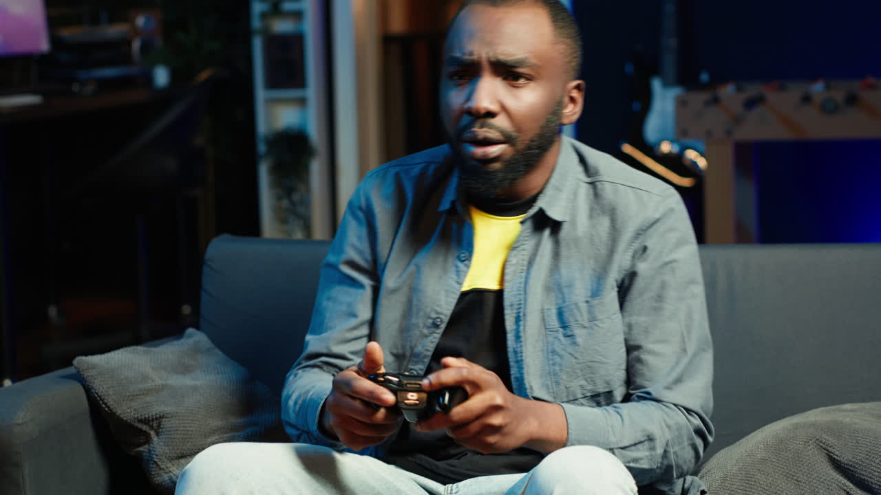 Man putting face in hands in frustration after being defeated in videogame