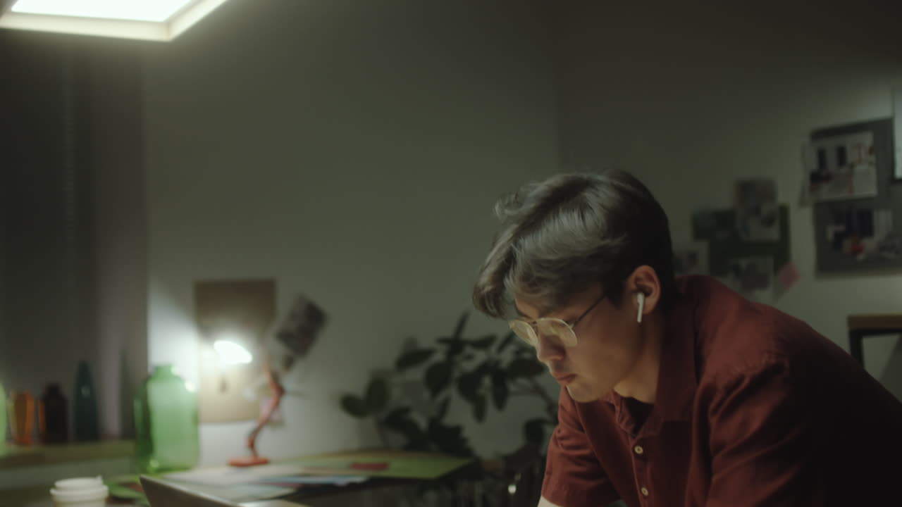 Young man working or studying on a laptop at night