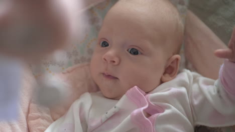 lovely calm baby girl looking at toys over the head