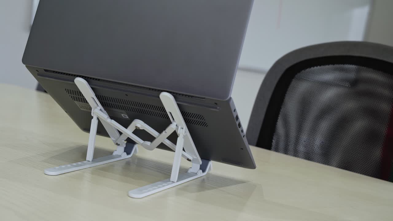 Close-up of a laptop being set on dual foldable stands—ideal for productivity, tech gear reviews, or desk ergonomics videos.