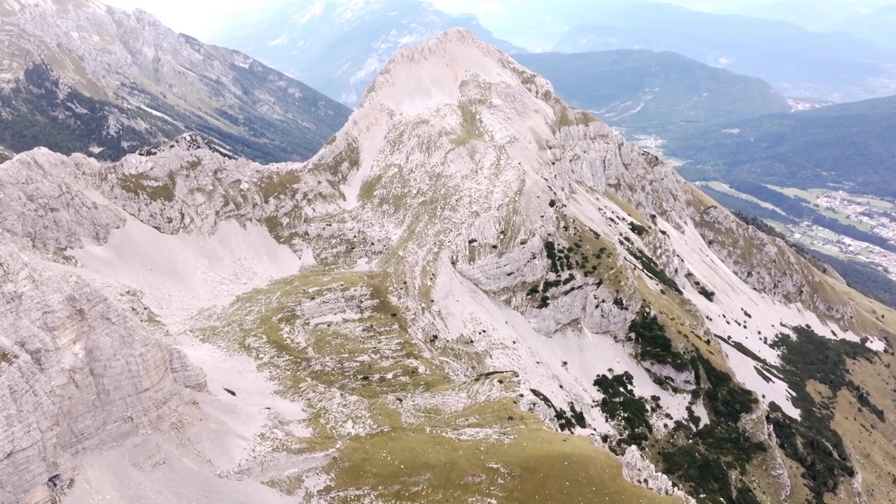 Riprese aeree dall'alto di una valle di montagna che si trasforma in pareti rocciose a Molveno, Italia