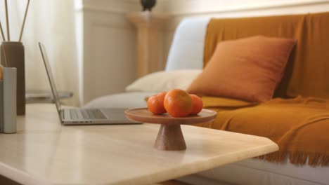 oranges and a laptop sit on living room table