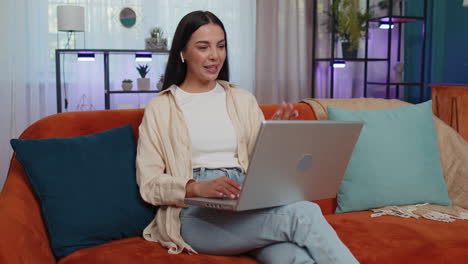 Mujer-Sentada-En-El-Sofá-De-Casa,-Mirando-La-Cámara,-Haciendo-Videoconferencias-Con-Amigos-O-Familiares