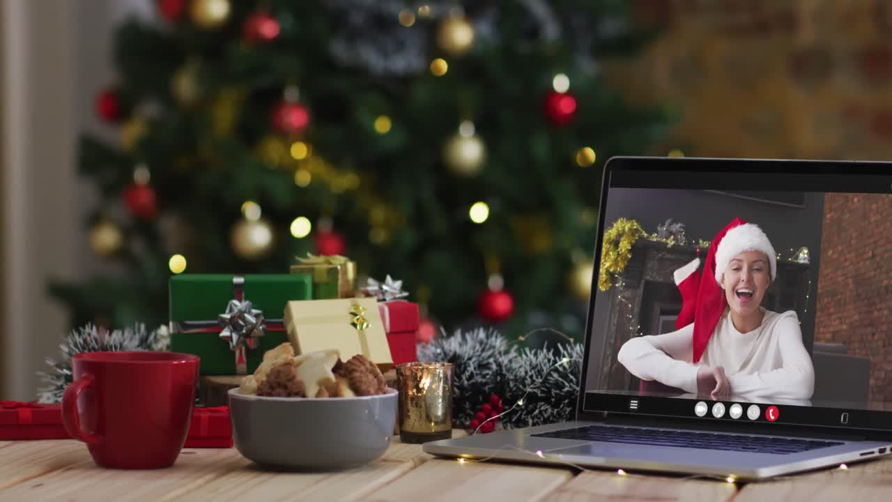 mujer caucásica feliz en videollamada en computadora portátil, con decoraciones de navidad y árbol