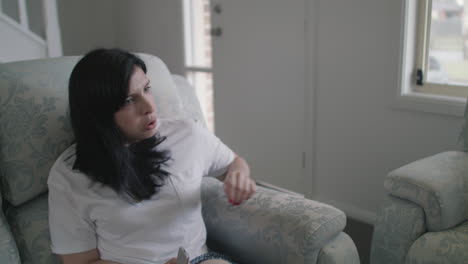 women slouching into couch then reclining to watch tv