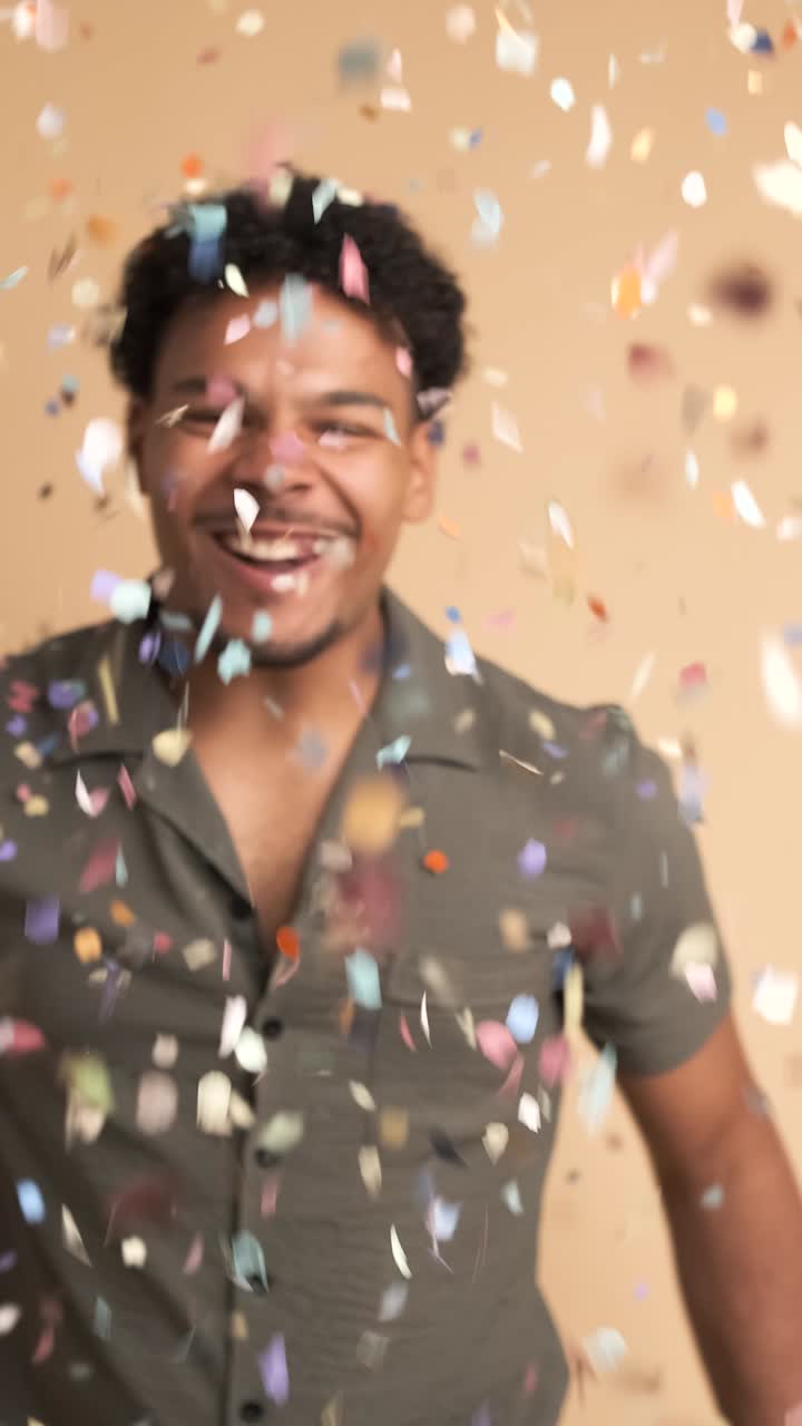 Cheerful man celebrating big win showered in confetti