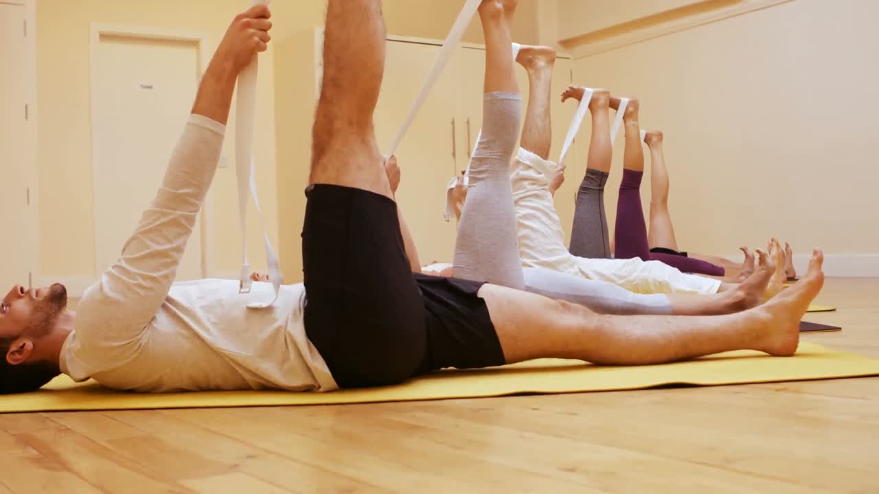 grupo de personas que realizan ejercicios de estiramiento utilizando bandas de resistencia