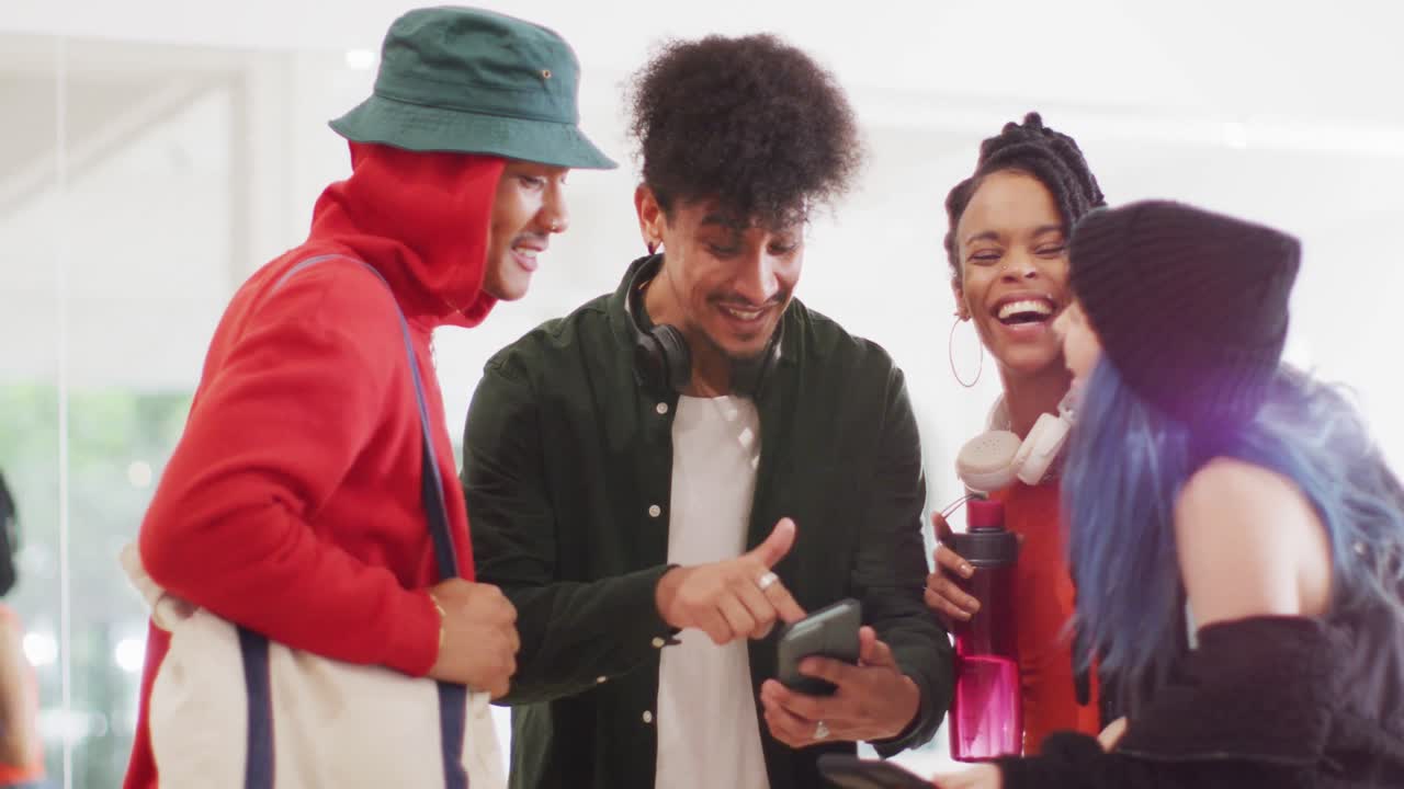 bailarines hombres y mujeres felices y diversos hablando y usando teléfonos inteligentes en un estudio de baile, cámara lenta