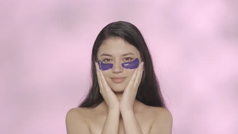 woman applying eye patches for skincare treatment