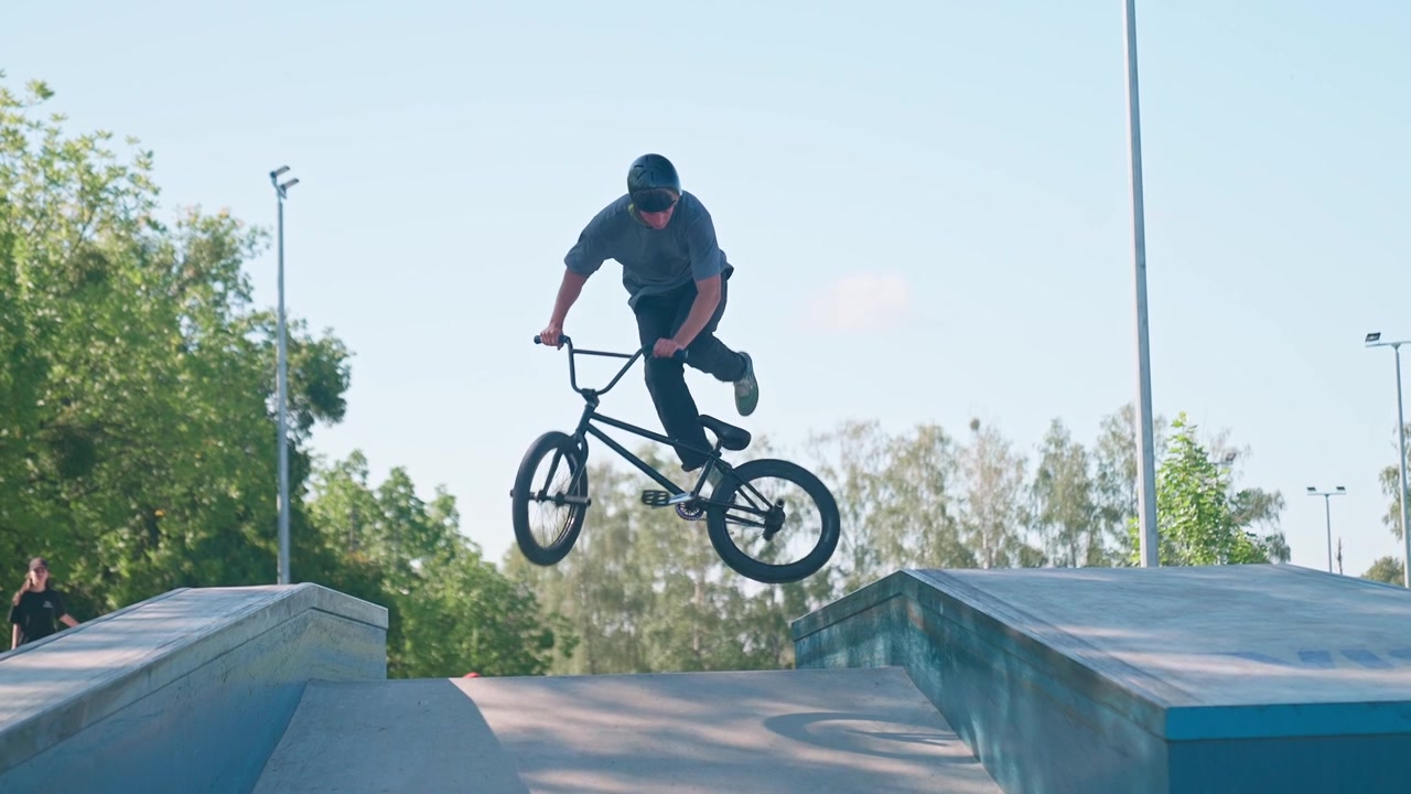 Młody mężczyzna na rowerze BMX wykonujący skok w skateparku