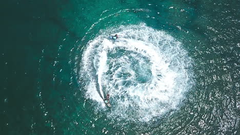 aerial shot of two jetsurf riders performing tricks in beautiful ocean