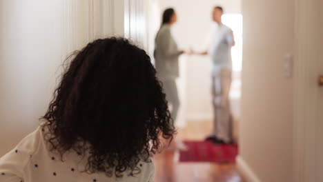 atrás, los padres peleando y la niña en el pasillo