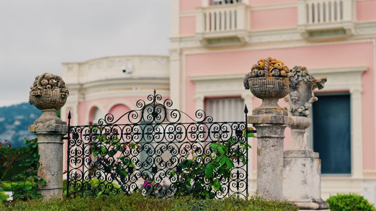 Primo piano di un pilastro decorativo in pietra nel cortile di Villa Ephrussi de Rothschild con una vista sfocata sullo sfondo
