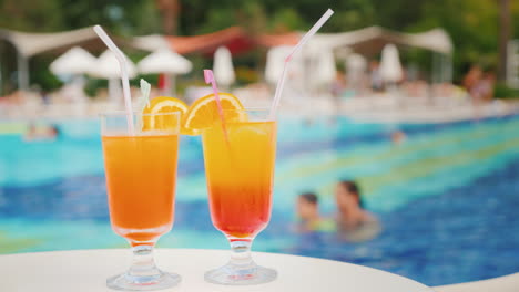 two exotic cocktails on the background of the pool at the tourist resort