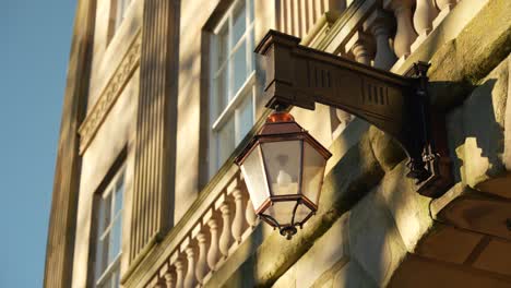 close-up of old-fashioned brass lamp on buxton crescent building, english heritage