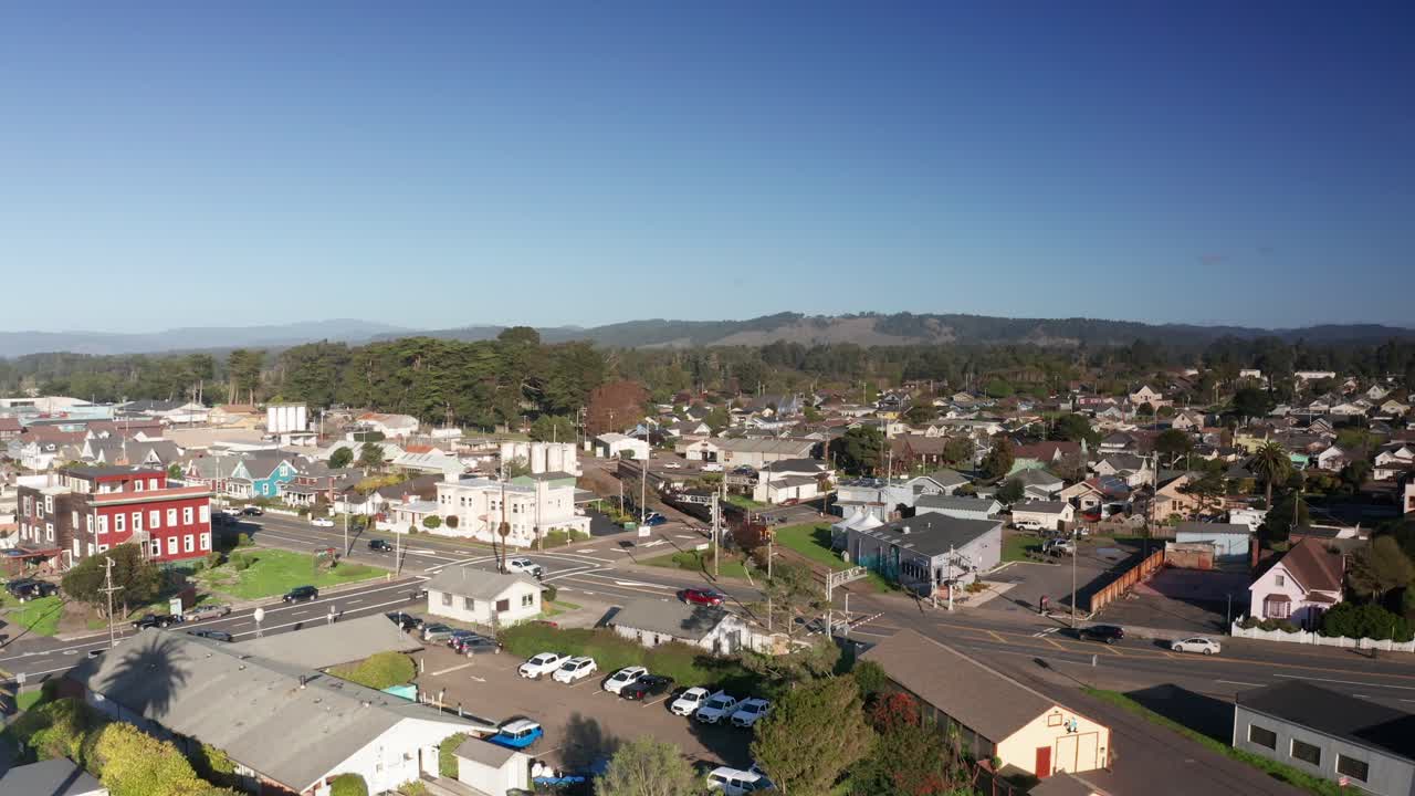 Low rising aerial shot of the historic Skunk Train traveling through Fort Bragg, California. 4K