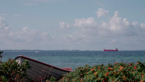 Ruderboot-Am-Ufer-Mit-Schiff-Im-Horizont-In-Zeitlupe