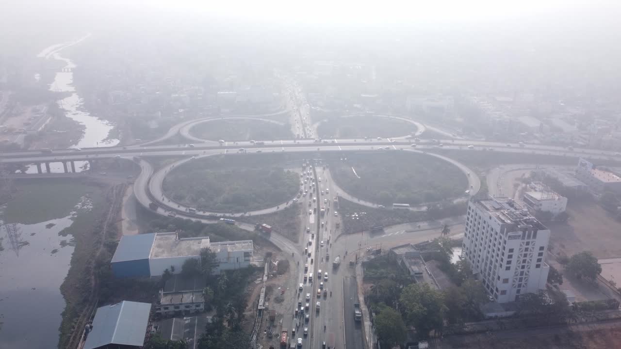 Aerial birds eye view of the iconic cloverleaf interchange of MADURAVOYAL FLYOVER BRIDGE in Chennai captured by drone under smog conditions on a bright morning with smooth flowing traffic