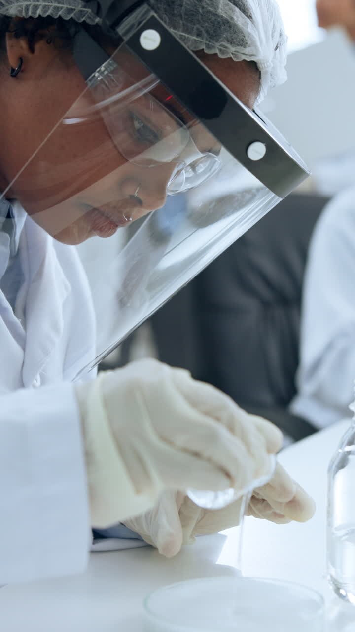 Scienziato che versa liquido in una capsula di Petri in laboratorio