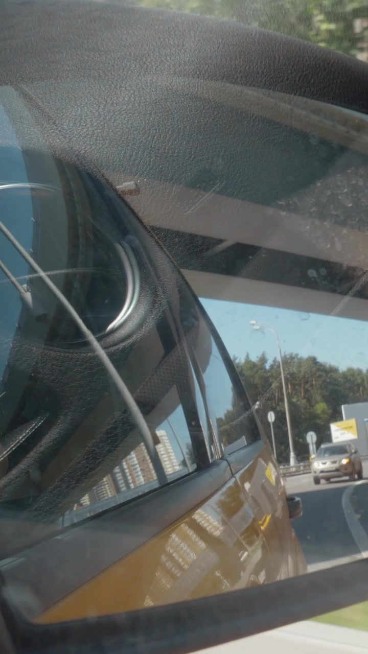 Vista della città e del traffico nel riflesso dello specchietto laterale dell'auto