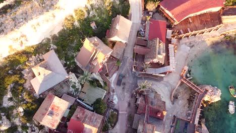 Wooden-village-on-Mediterranean-sea-coastline,-aerial-top-down-view