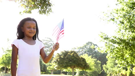 una niña agitando la bandera estadounidense.