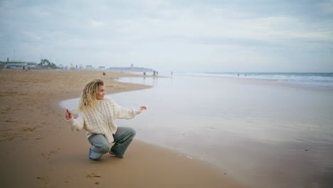 mujer lanzando piedras agua océano en un día nublado. niña pensando descansando en la orilla del mar