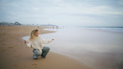 woman throwing stones water ocean on cloudy day. thinking girl resting seaside