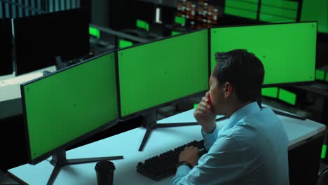 vista lateral de un hombre asiático cansado bostezando antes de dormir mientras trabaja con múltiples monitores de computadora simulados en la oficina