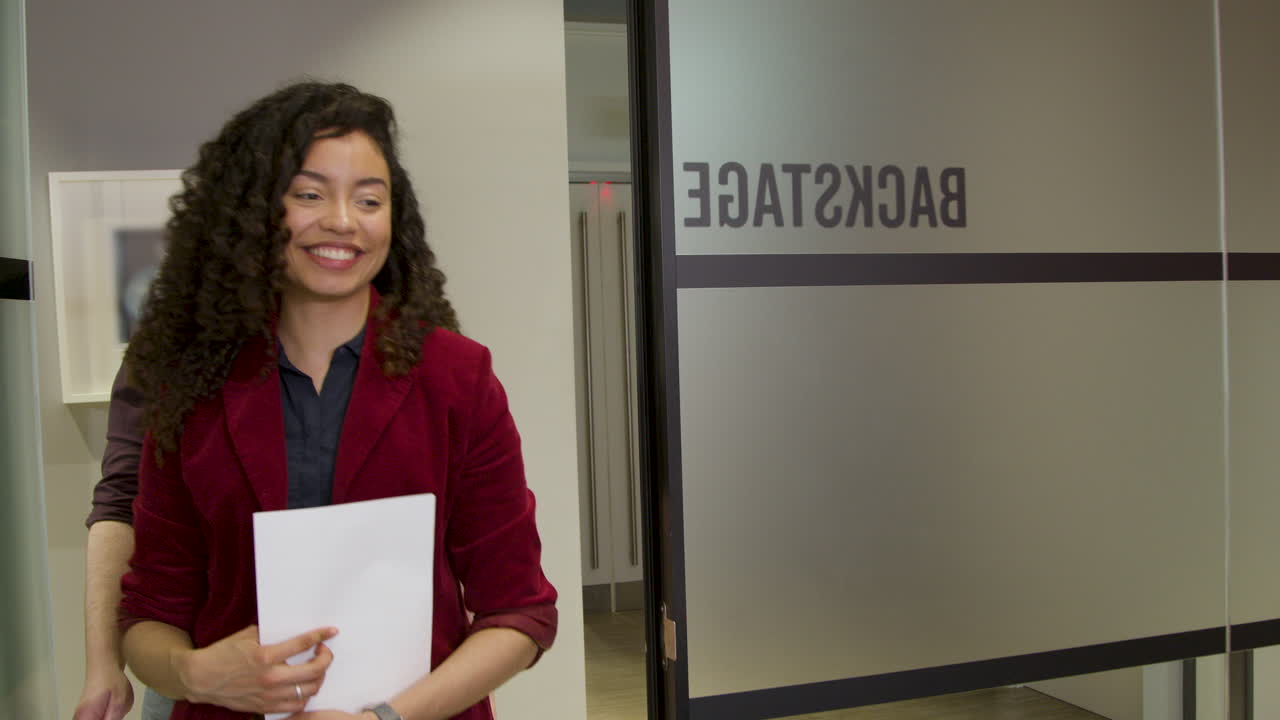 los colegas entran a la sala de reuniones y comienzan a hablar