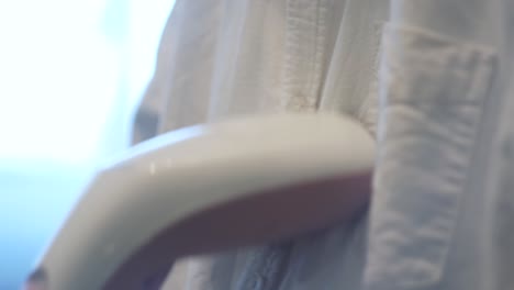 persona planchando una camisa blanca