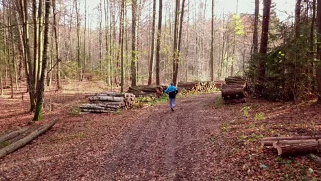 Hombre-Corriendo-Por-Un-Sendero-Forestal-En-El-Paisaje-Otoñal