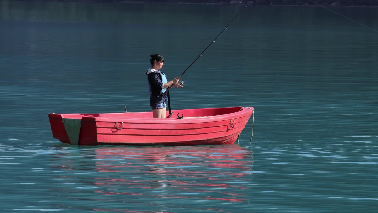 la mujer en el barco atrapa un pez en el giro en noruega.