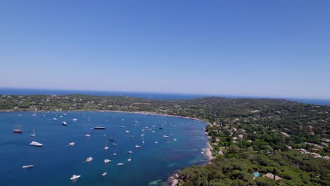 aerial flight over bay of st tropez with many luxury parking boats during sunny day in france