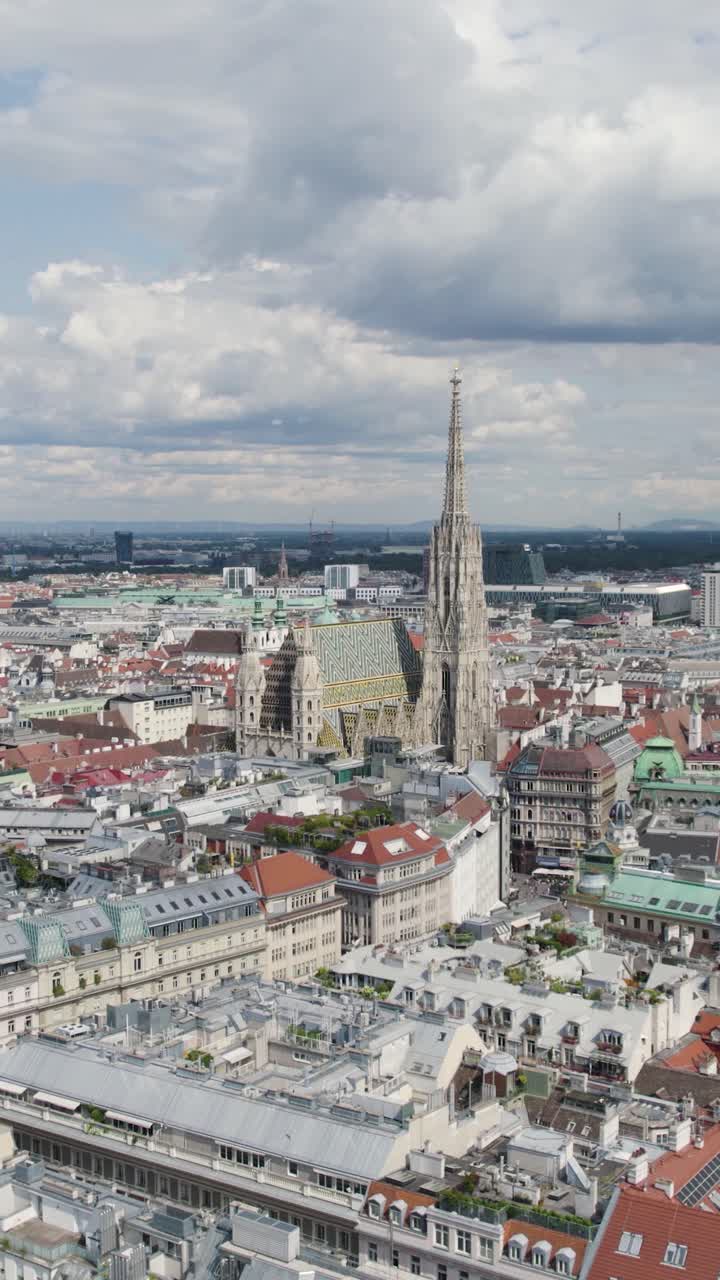 Aerial view of St. Stephen's Cathedral and surrounding cityscape of Vienna, Austria, under cloudy sky. vertical video