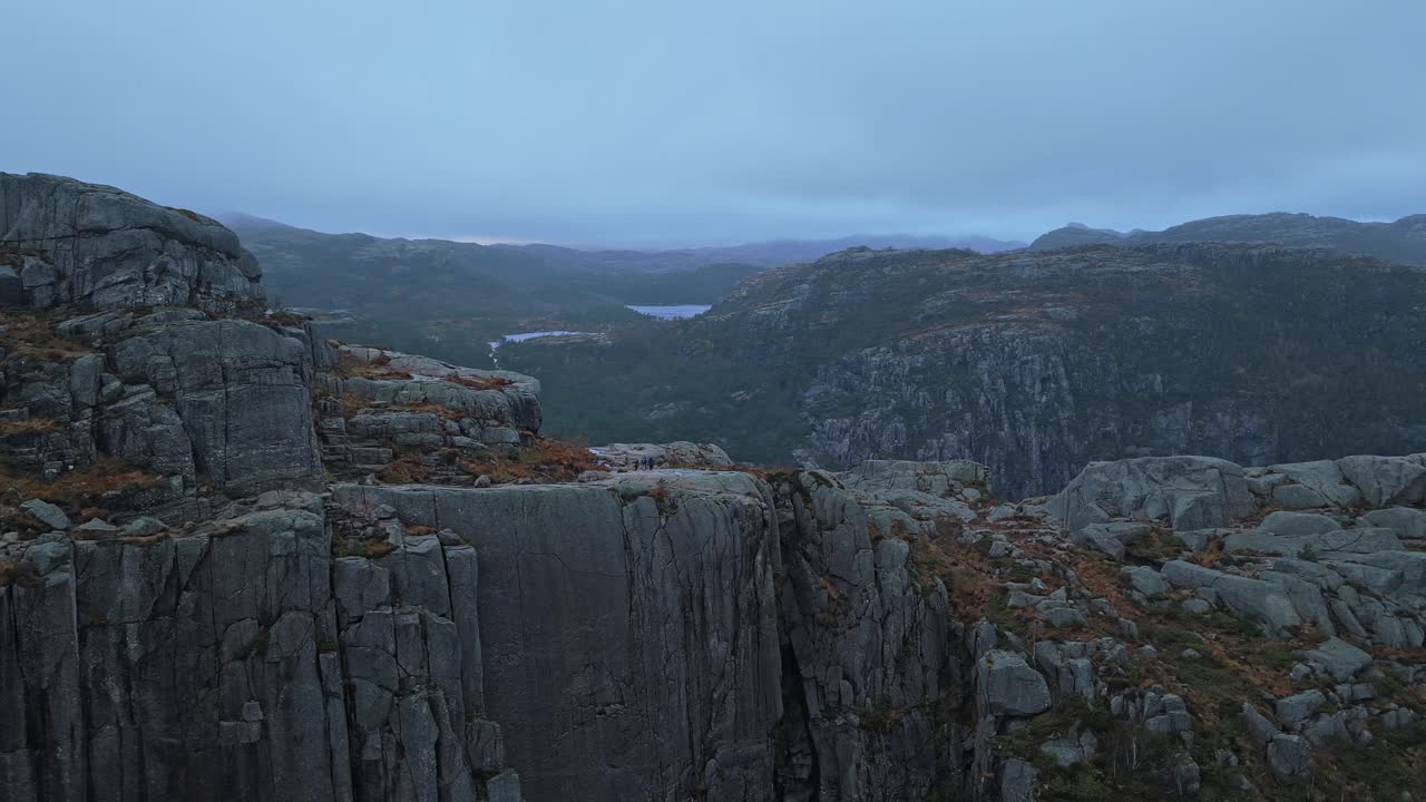Luftfoto af familiegruppe, der vandrer sammen på Preikestolen-klippen i Norge