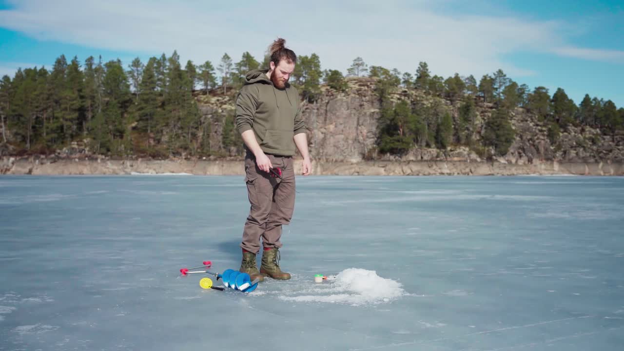 Man Preparing Ice Hole In Frozen Lake For Ice Fishing In Indre Fosen, Norway