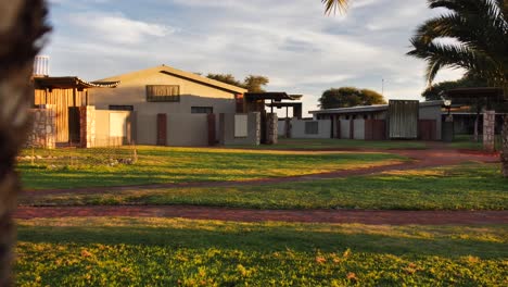 un albergue en namibia con casas de piedra bajo la luz dorada justo antes del atardecer.