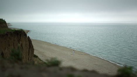 Tranquil-scenery-sandy-beach-cloudy-morning.-High-hill-standing-on-seacoast.