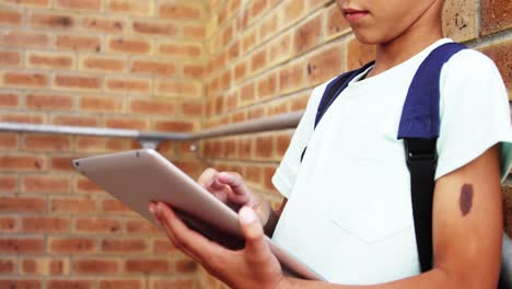 escolar que usa una tableta digital en la escuela
