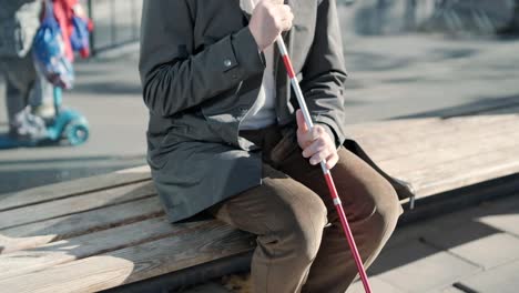 blinded man waiting for bus at a bus station