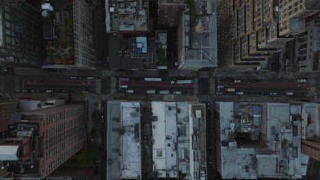 Aerial-birds-eye-overhead-top-down-panning-view-of-traffic-in-streets-of-city.-Regular-crossroads-in-rectangle-street-grid.-Manhattan,-New-York-City,-USA