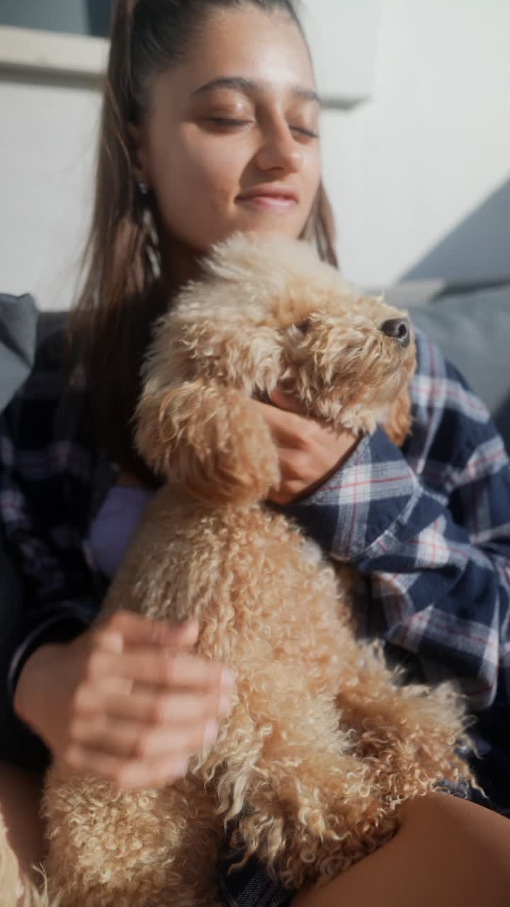 Woman cuddling a fluffy poodle dog