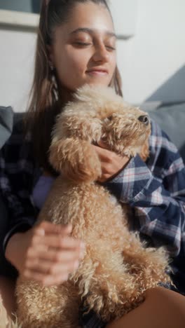 woman cuddling a fluffy poodle dog