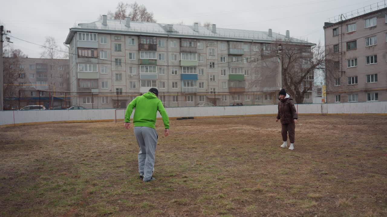 Игроки отрабатывают передачи, любительская футбольная тренировка на открытом воздухе, игроки-любители практикуют передачи под облачным небом, люди занимаются неформальными упражнениями по передаче мяча на просторном открытом поле