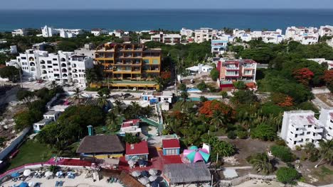 aerial drone forward moving shot over isla mujeres island with beach clubs and resorts in quintana roo mexico on a bright sunny day