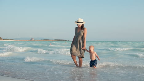 Mujer-Sonriente-E-Hijo-Divirtiéndose-En-La-Costa.-Mamá-Y-Niño-Jugando-En-Olas.