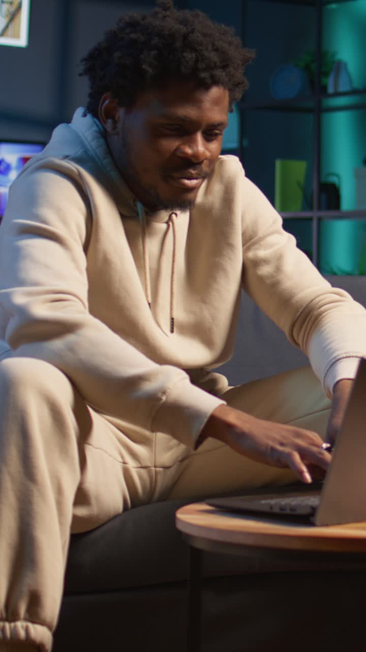 African American Man Typing on Laptop at Home in the Evening