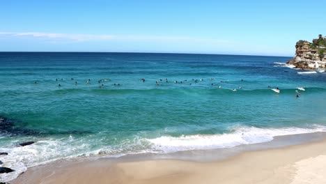 a big group of surfers are swimming in the ocean at bronte beach in sydney australia