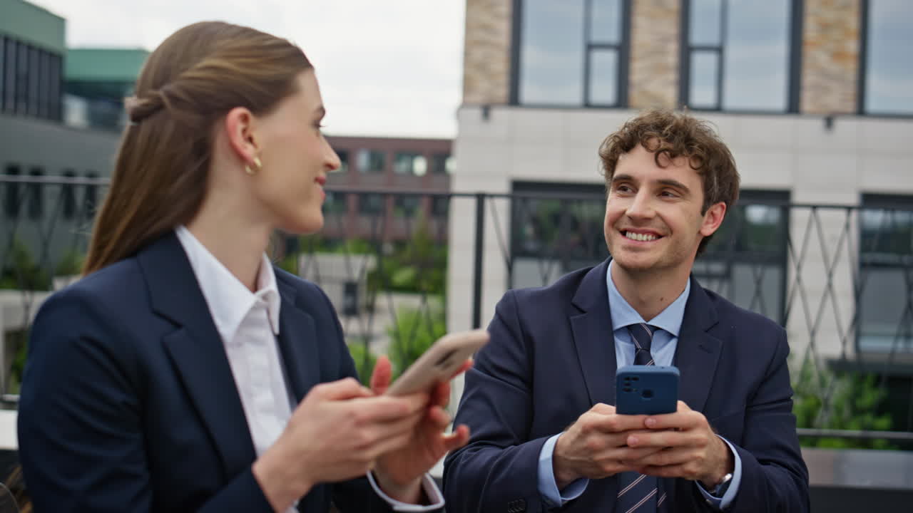 Business people engaging smartphones working at office terrace outdoors closeup